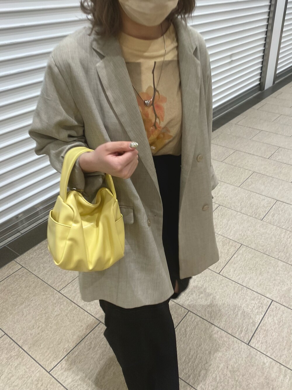 イエロー系のTシャツ/カットソー、イエロー系のボストンバッグ、ブラック系のスカートを着用したレディースの春コーディネートの2枚目の写真
