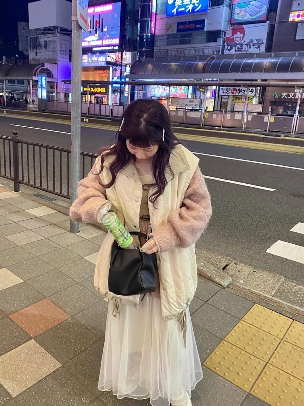 ブラック系のショルダーバッグ、ピンク系のカーディガン/ボレロ、ホワイト系のブルゾンを着用したレディースの冬コーディネートの2枚目の写真