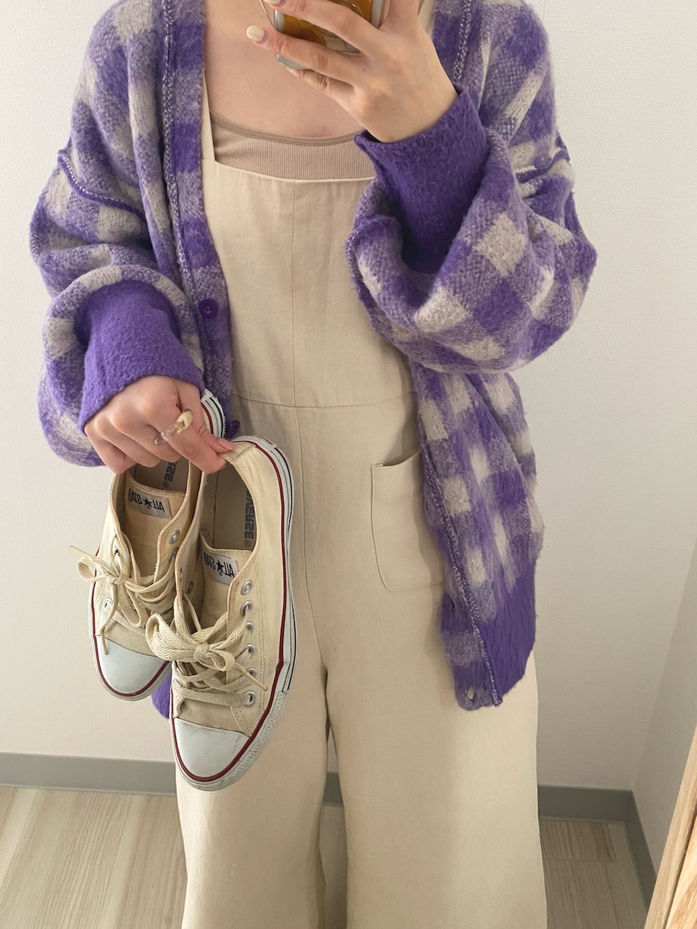 ホワイト系のスニーカー、パープル系のカーディガン/ボレロ、ホワイト系のサロペット/オーバーオールを着用したレディースの冬コーディネートの2枚目の写真