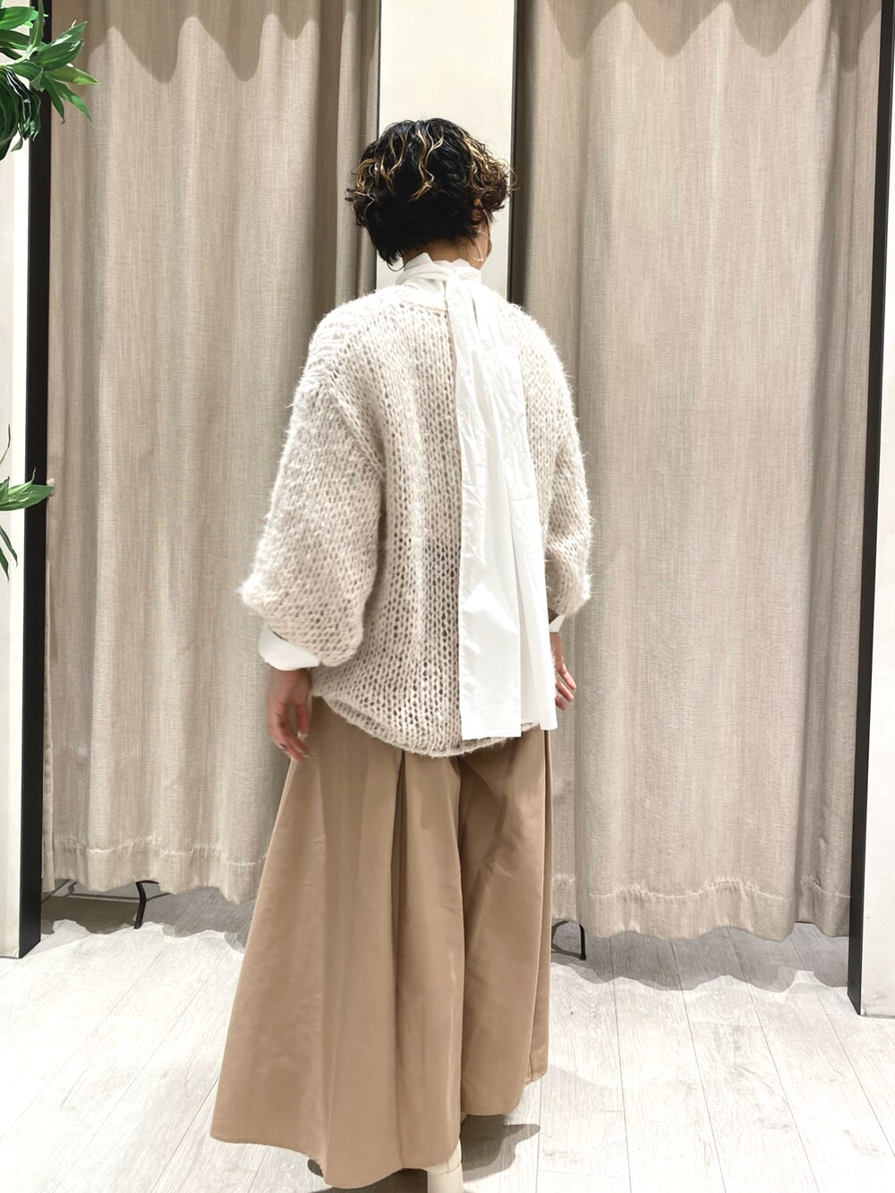 ホワイト系のニット/セーター、ホワイト系のシャツ/ブラウス、ブラック系のその他パンツを着用したレディースの冬コーディネートの2枚目の写真