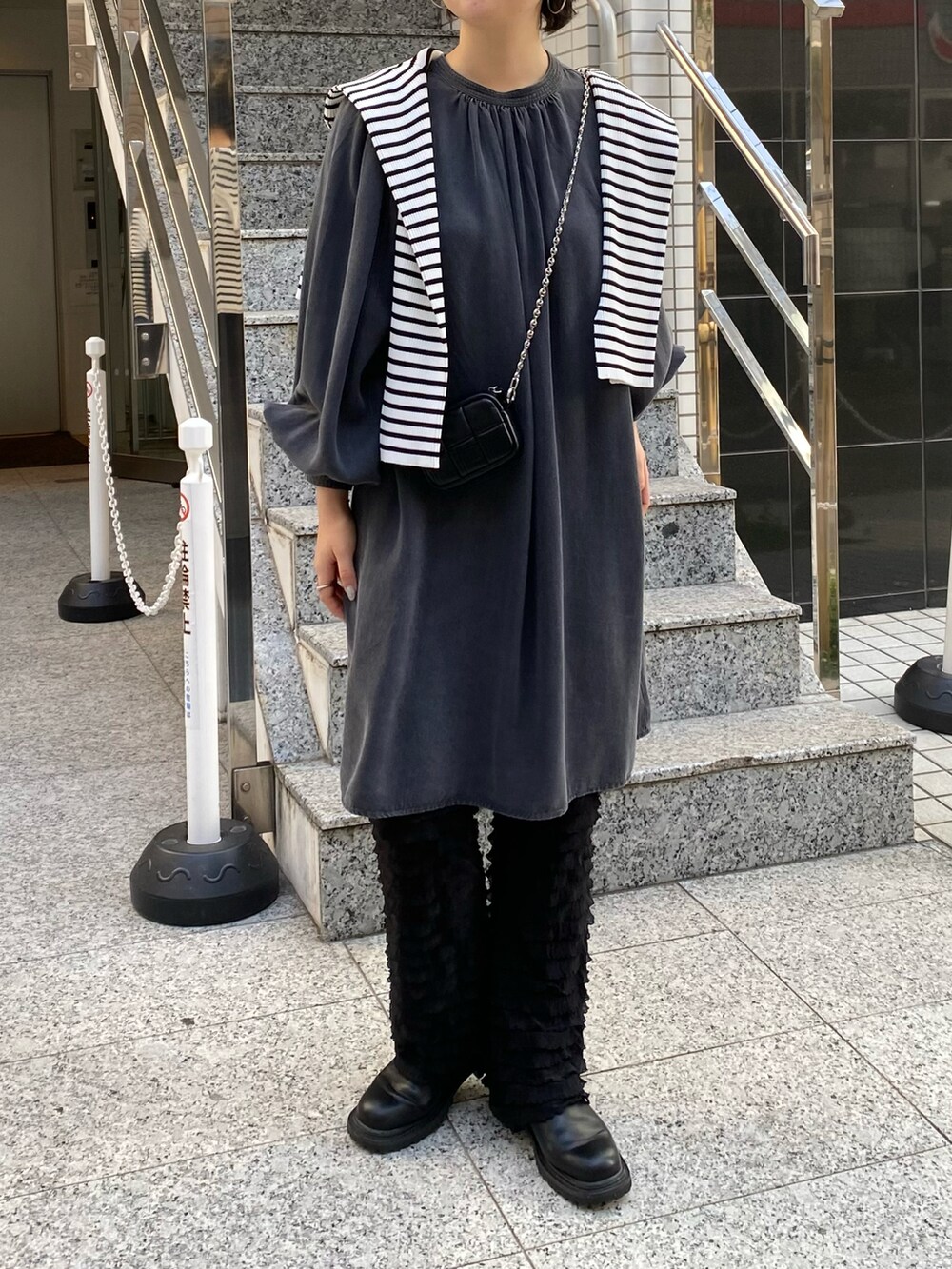 ブラック系のワンピース、ブラック系のその他パンツ、ホワイト系のカーディガン/ボレロを着用したレディースの冬コーディネートの2枚目の写真