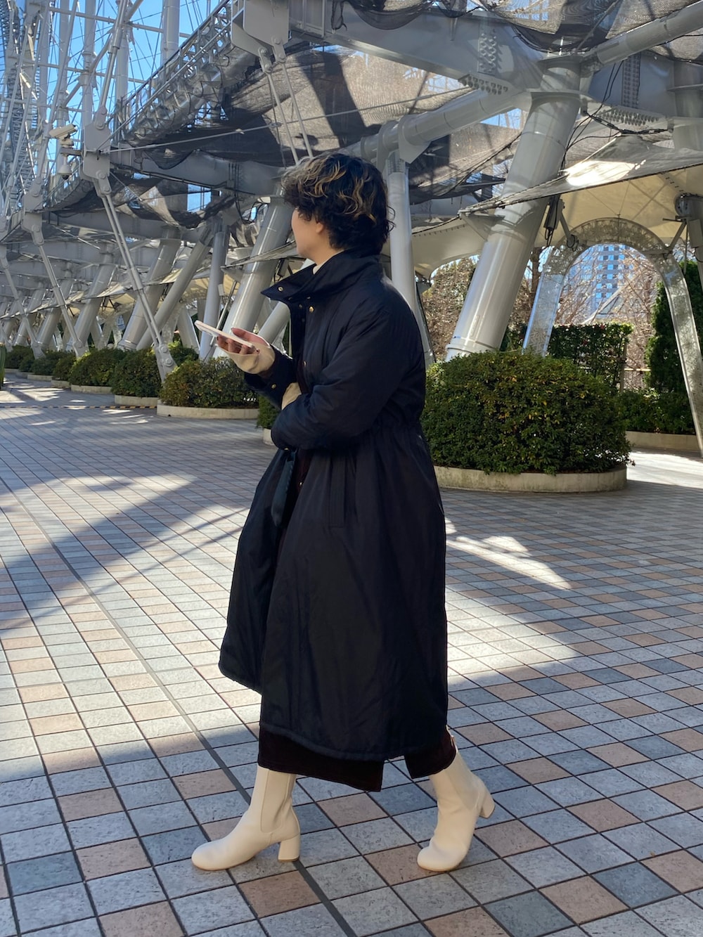 ブラック系のワンピース、ブラック系のダウンジャケット/コート、ホワイト系のブーツを着用したレディースの冬コーディネートの2枚目の写真