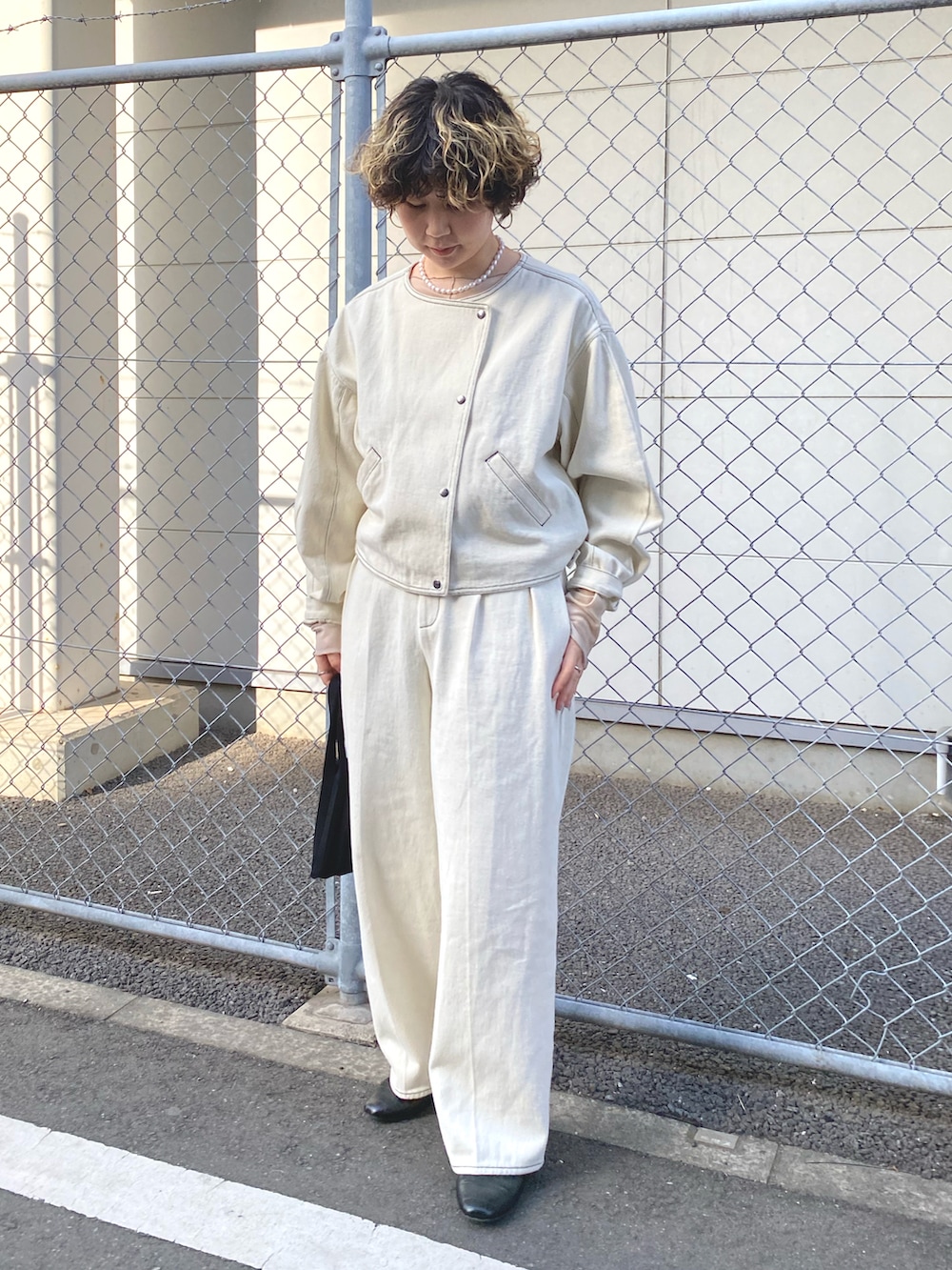 ホワイト系のデニムジャケット、ホワイト系のデニムパンツ、ベージュ系のTシャツ/カットソーを着用したレディースの冬コーディネートの4枚目の写真