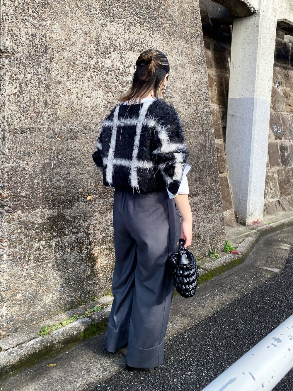 ホワイト系のTシャツ/カットソー、ブラック系のニット/セーター、グレー系のその他パンツを着用したレディースの冬コーディネートの2枚目の写真