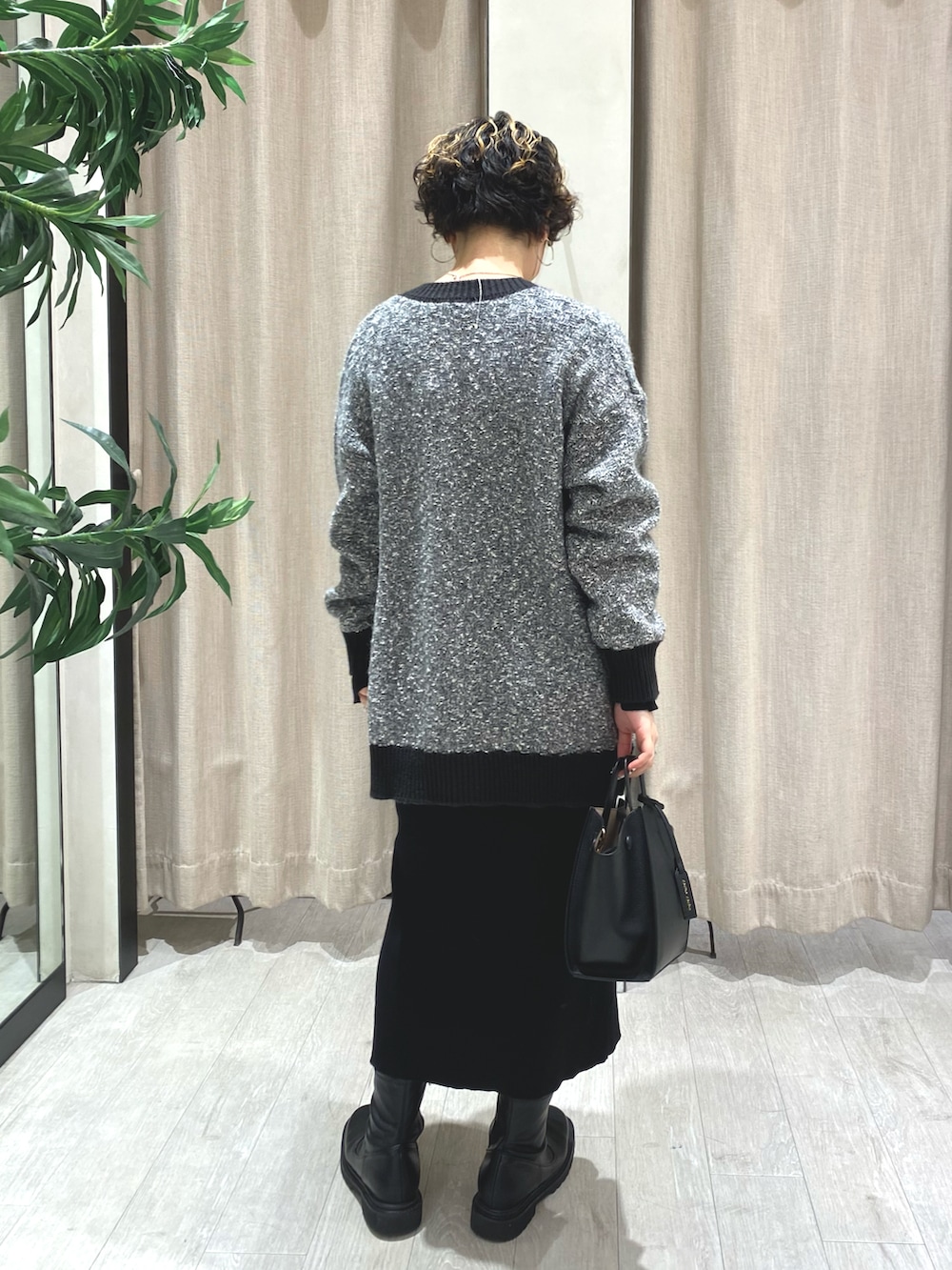 グレー系のカーディガン/ボレロ、ブラック系のワンピース、ブラック系のハンドバッグを着用したレディースの冬コーディネートの2枚目の写真