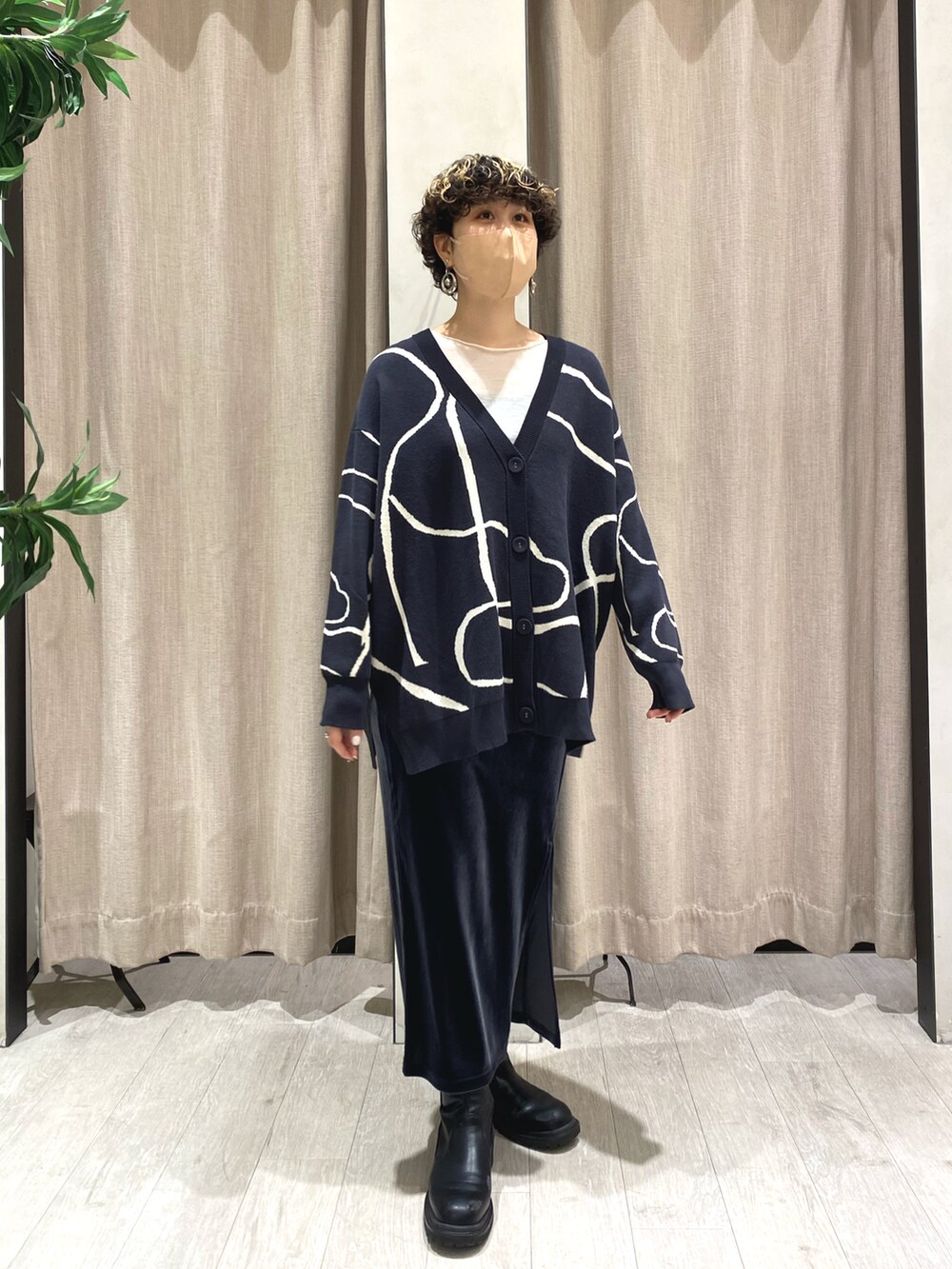 グレー系のカーディガン/ボレロ、ホワイト系のTシャツ/カットソー、グレー系のスカートを着用したレディースの冬コーディネートの2枚目の写真