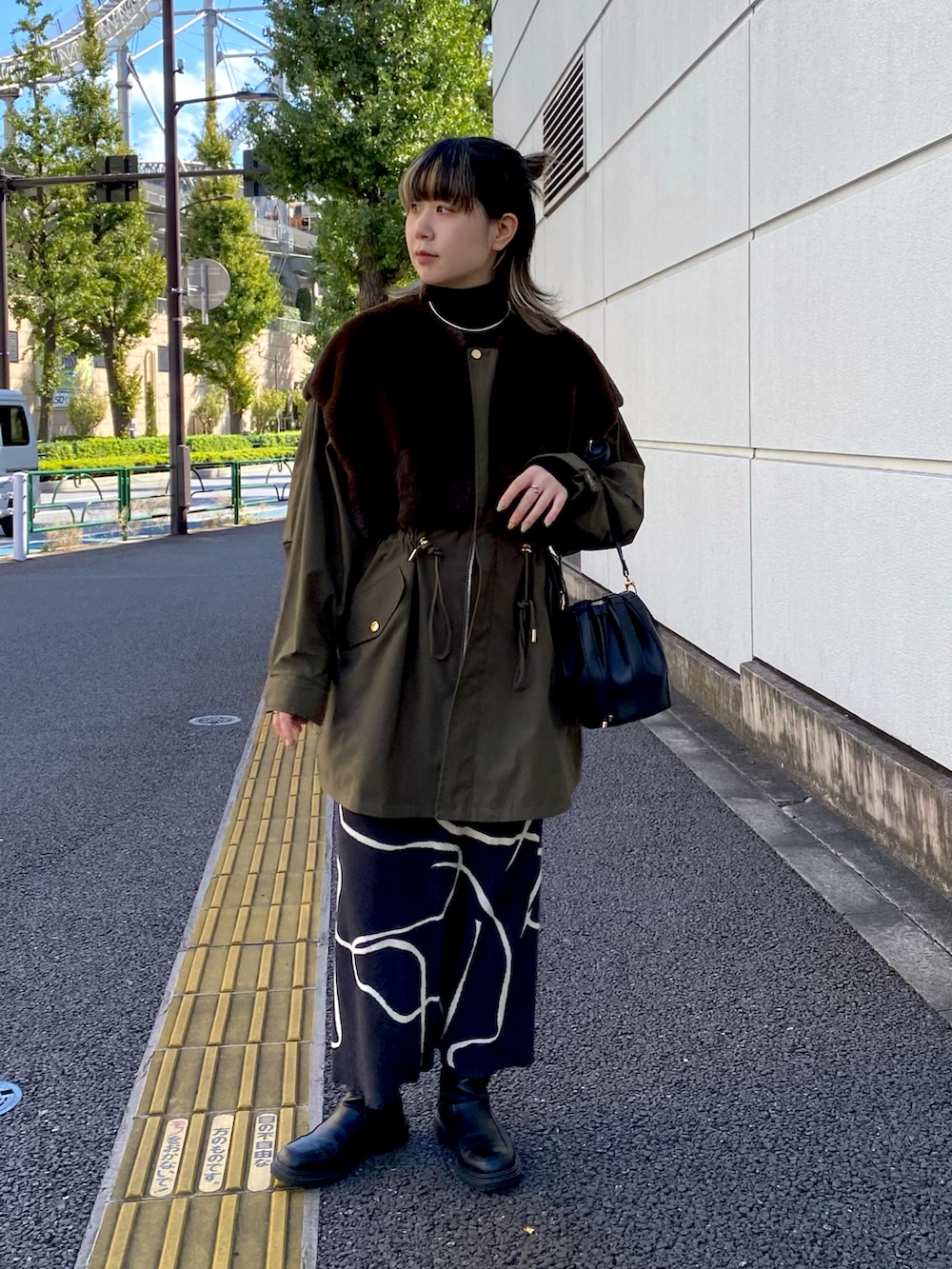 グリーン系のジャケット/アウター、グレー系のスカートを着用したレディースの秋コーディネートの2枚目の写真