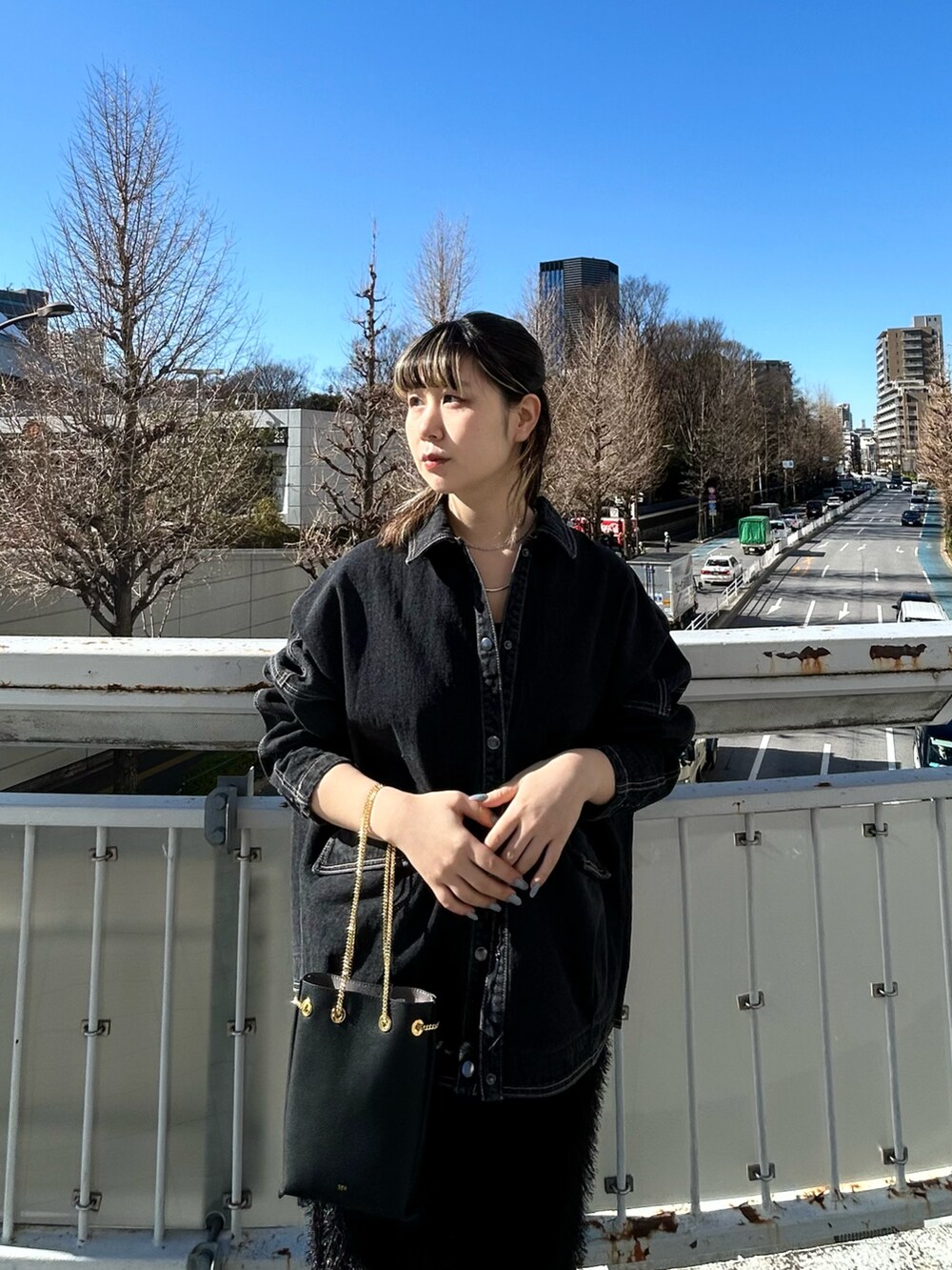 ブラック系のデニムジャケット、ブラック系のスカートを着用したレディースの冬コーディネートの2枚目の写真