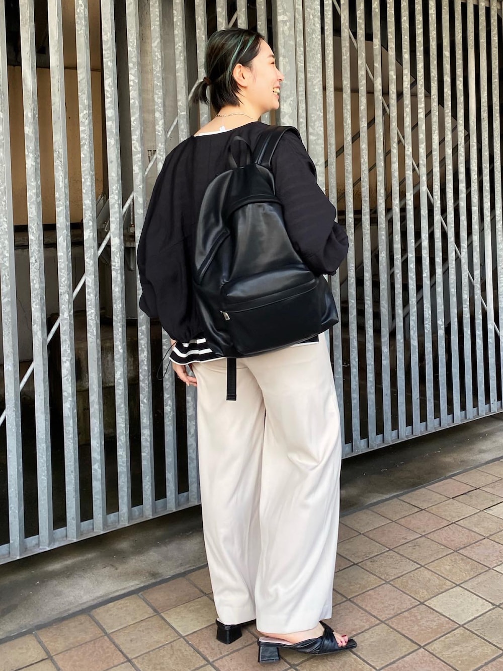 ブラック系のブルゾン、ブラック系のTシャツ/カットソー、ブラック系のバックパック/リュックを着用したレディースの夏コーディネートの2枚目の写真