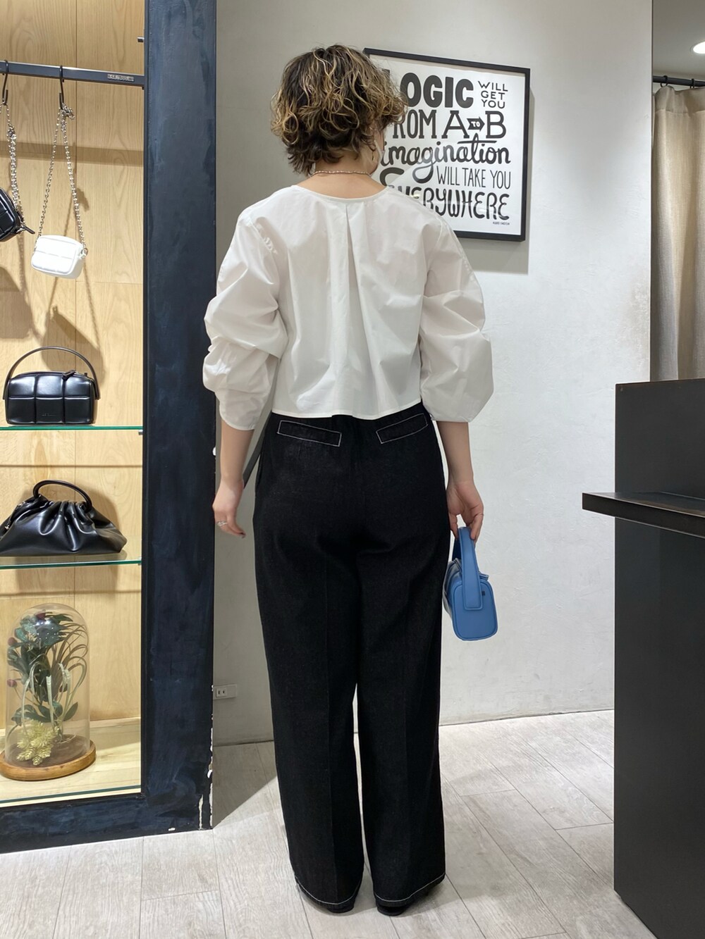 ホワイト系のデニムパンツ、ブルー系のハンドバッグを着用したレディースの冬コーディネートの2枚目の写真