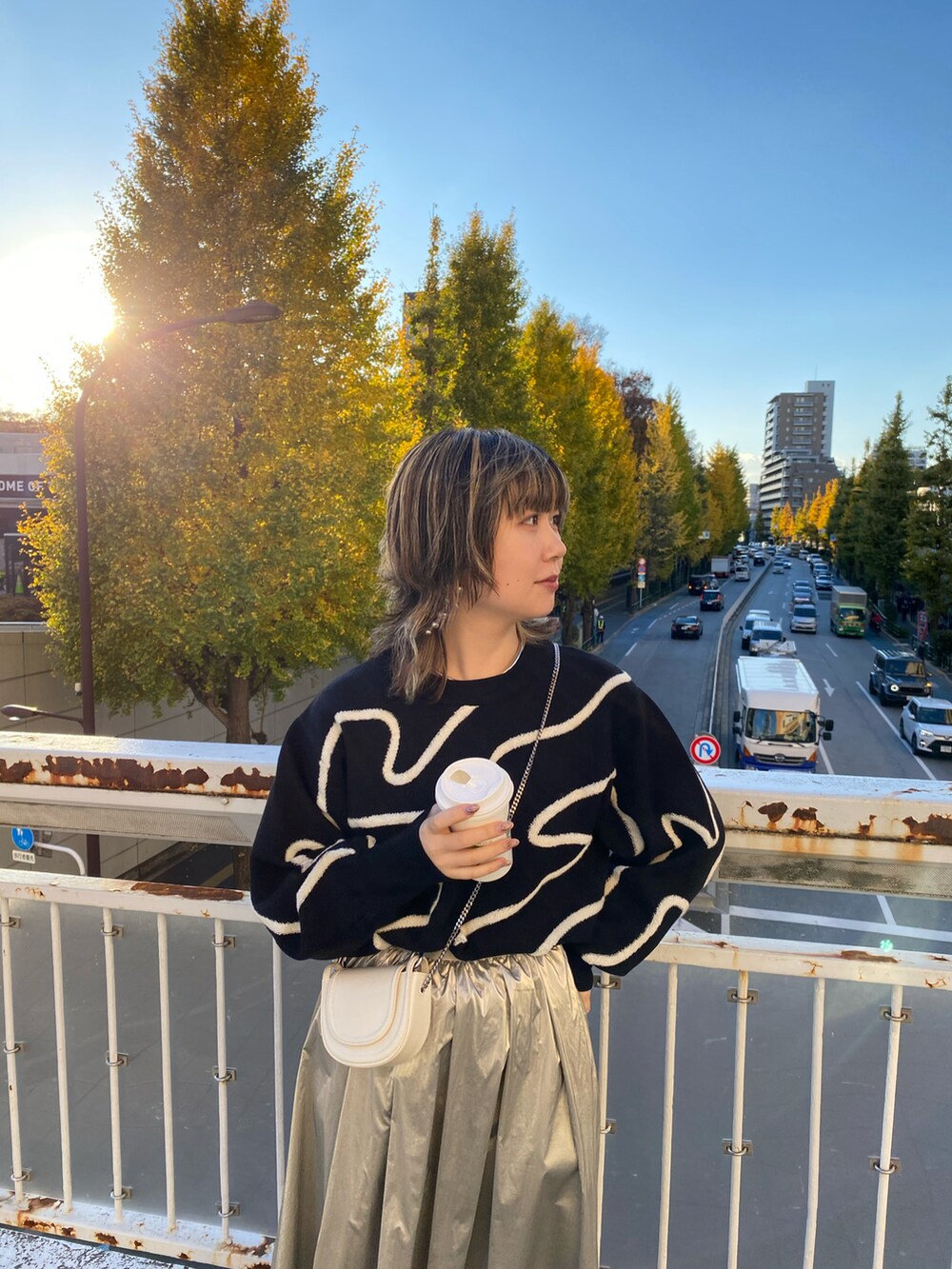 ブラック系のニット/セーター、シルバー系のスカートを着用したレディースの冬コーディネートの2枚目の写真