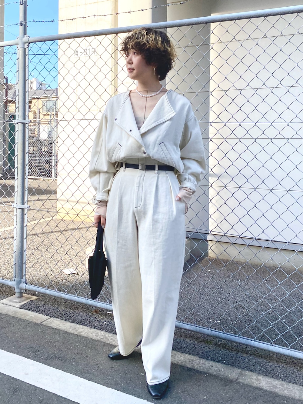 ホワイト系のデニムジャケット、ホワイト系のデニムパンツ、ベージュ系のTシャツ/カットソーを着用したレディースの冬コーディネートの2枚目の写真