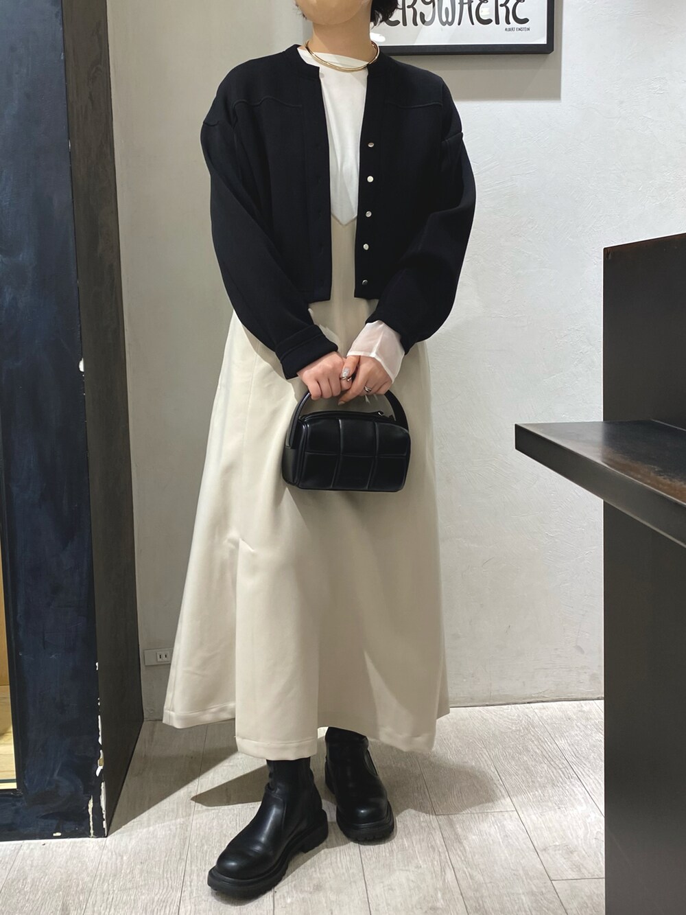 ホワイト系のワンピース、ブラック系のハンドバッグ、ホワイト系のTシャツ/カットソーを着用したレディースの冬コーディネートの2枚目の写真