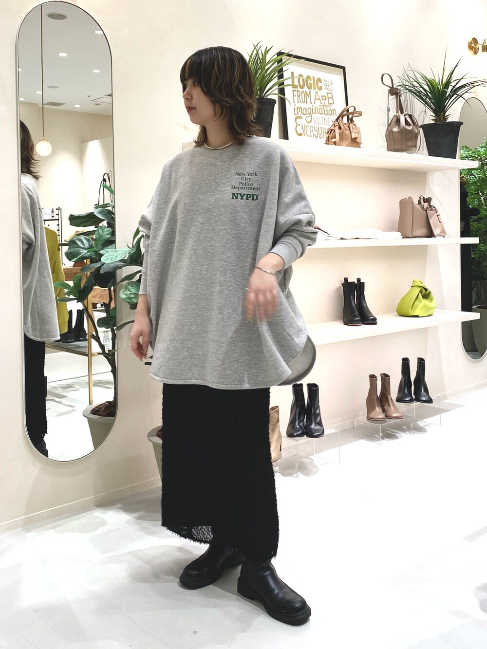 グレー系のスウェット、ブラック系のワンピースを着用したレディースの秋コーディネートの2枚目の写真