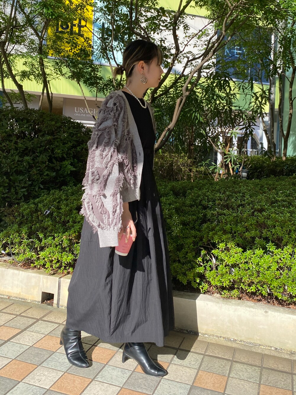 ブラック系のワンピース、グレー系のカーディガン/ボレロを着用したレディースの秋コーディネートの2枚目の写真