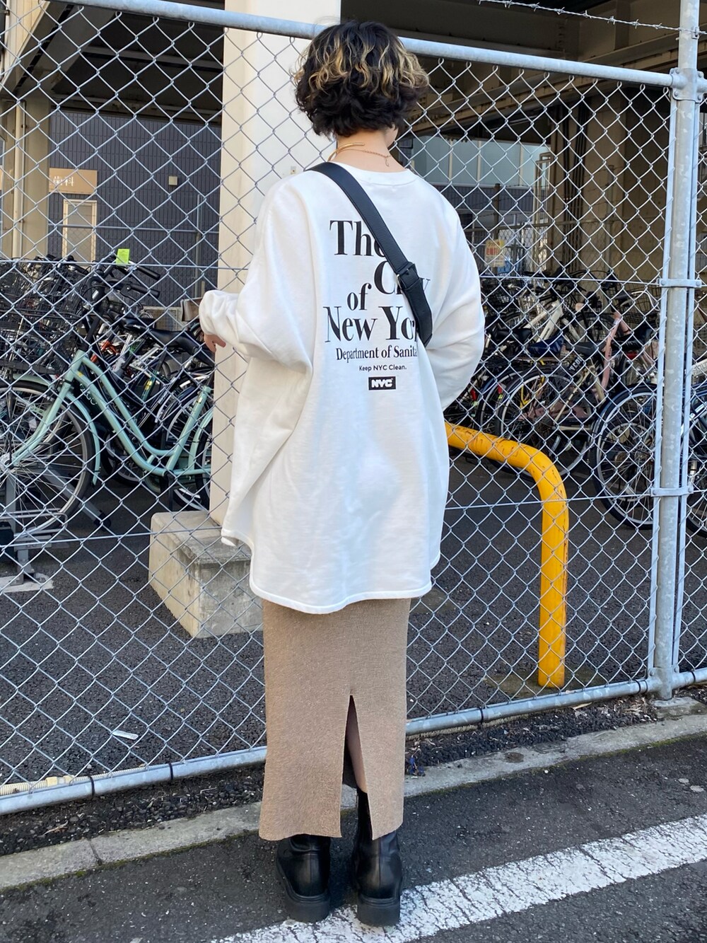 ホワイト系のTシャツ/カットソー、ベージュ系のスカート、ブラック系のショルダーバッグを着用したレディースの冬コーディネートの2枚目の写真