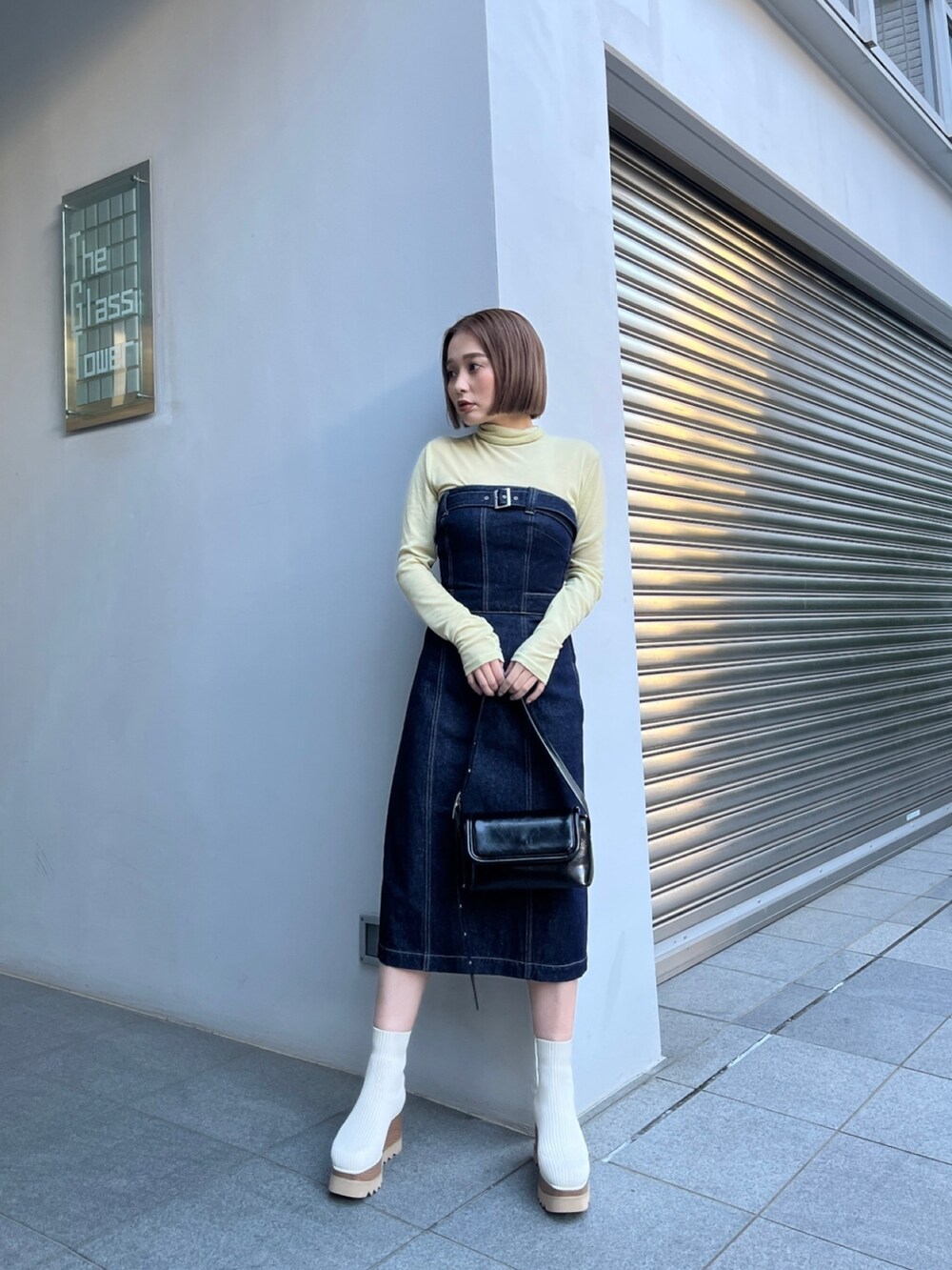 ブルー系のワンピース、ホワイト系のブーツ、イエロー系のTシャツ/カットソーを着用したレディースの秋コーディネートの2枚目の写真