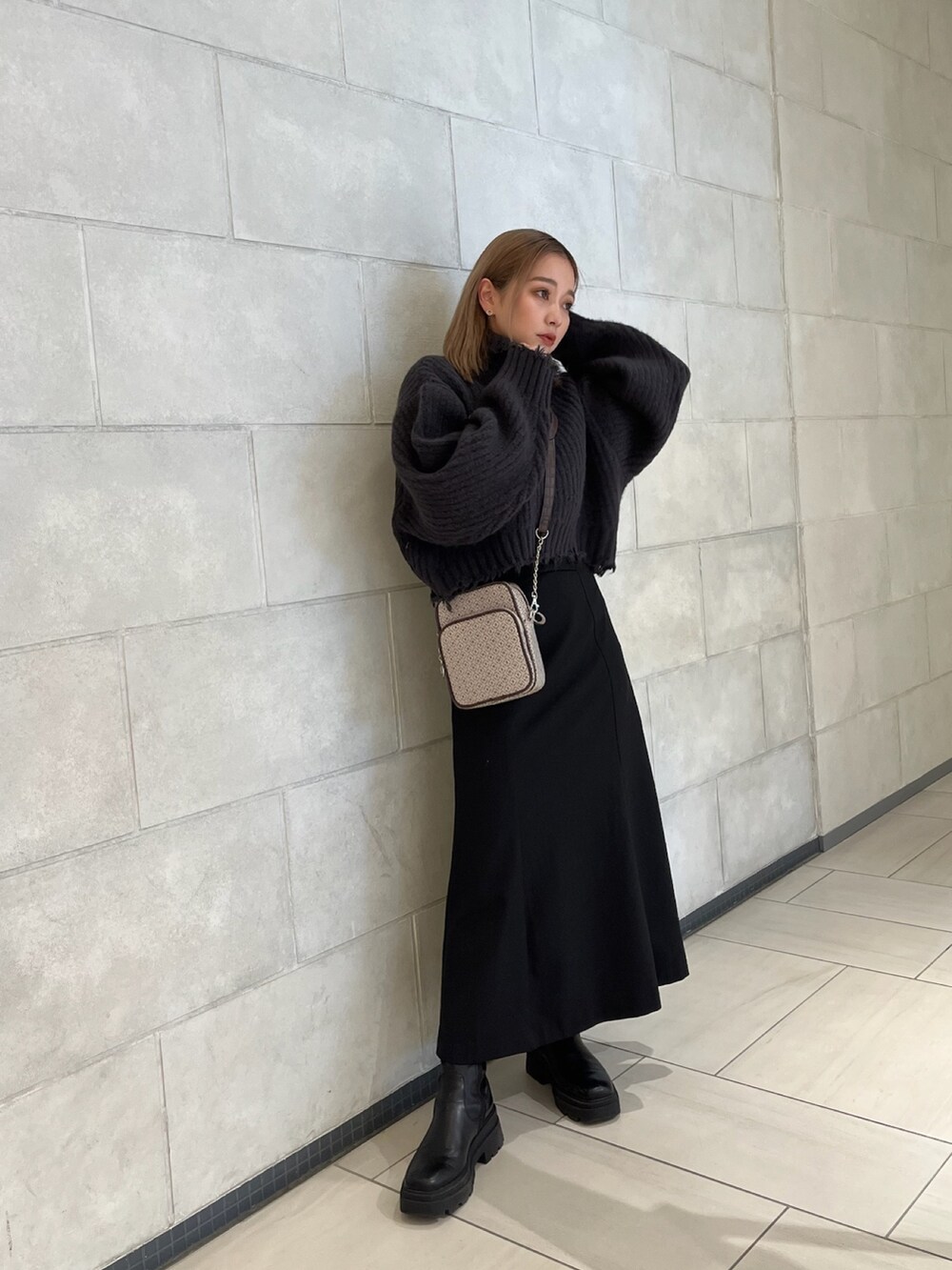 グレー系のニット/セーター、その他のショルダーバッグ、ブラック系のスカートを着用したレディースの秋コーディネートの2枚目の写真