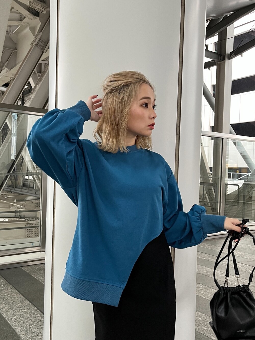 ブルー系のTシャツ/カットソー、ブラック系のスカート、ブラック系のハンドバッグを着用したレディースの冬コーディネートの5枚目の写真