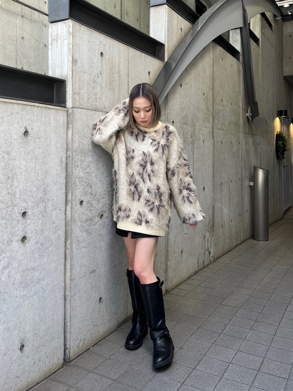 ホワイト系のニット/セーター、ブラック系のブーツを着用したレディースの秋コーディネートの2枚目の写真