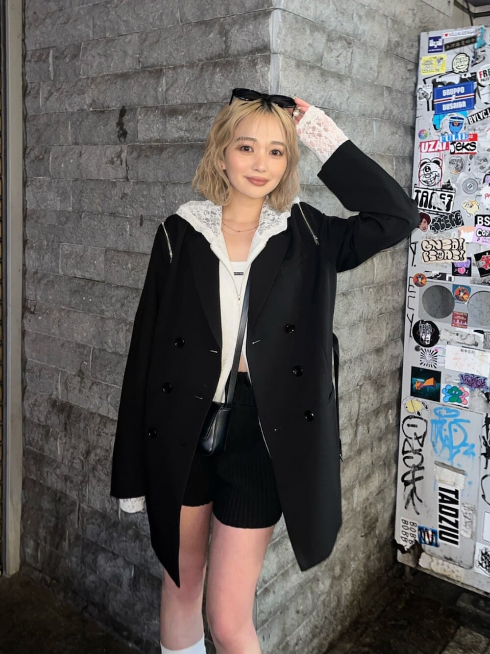 ブラック系のブーツ、ホワイト系のパーカー、ブラック系のテーラードジャケットを着用したレディースの春コーディネートの5枚目の写真