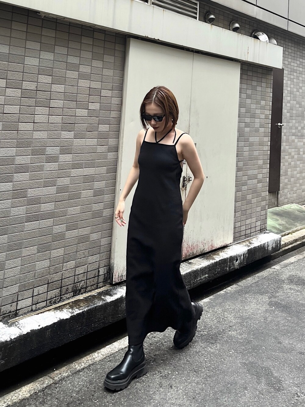 ブラック系のワンピース、ブラック系のサングラスを着用したレディースの春コーディネートの3枚目の写真