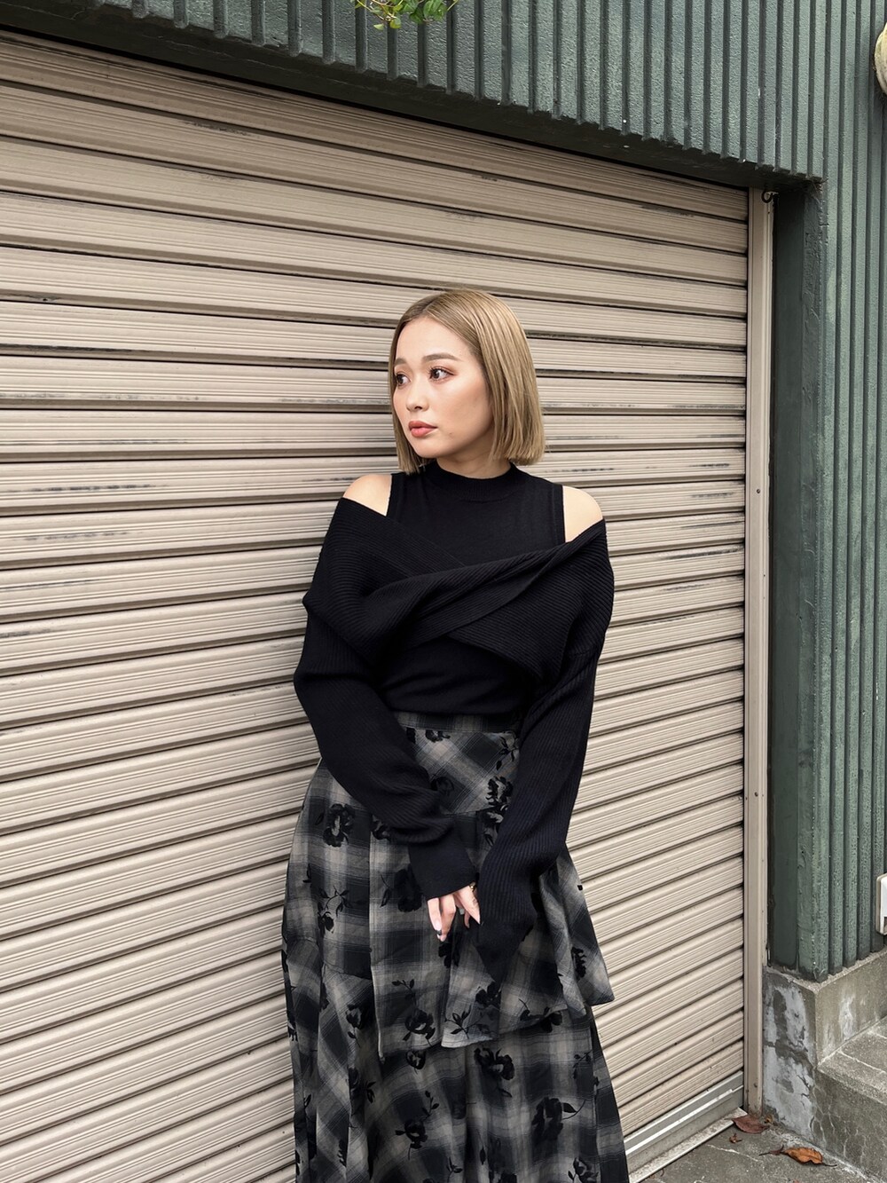 ブラック系のニット/セーター、ブラック系のスカート、ホワイト系のトートバッグを着用したレディースの冬コーディネートの5枚目の写真