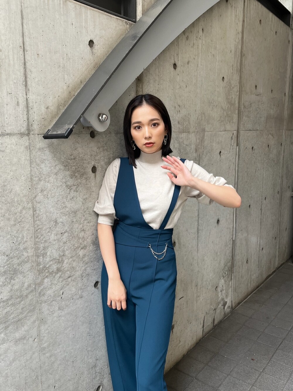 ブルー系のスラックス、ブラック系のブーツを着用したレディースの夏コーディネートの3枚目の写真