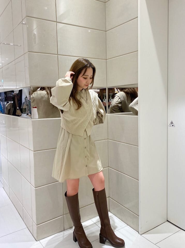 ブラウン系のブーツ、ブラック系のブーツ、ベージュ系のワンピースを着用したレディースの冬コーディネートの2枚目の写真