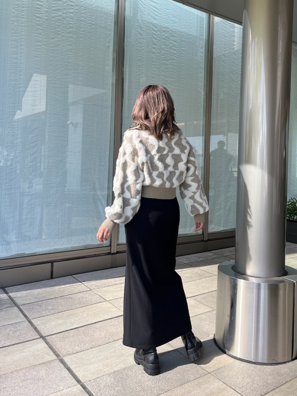 ベージュ系のニット/セーター、ブラック系のスカート、ブラック系のブーツを着用したレディースの秋コーディネートの4枚目の写真