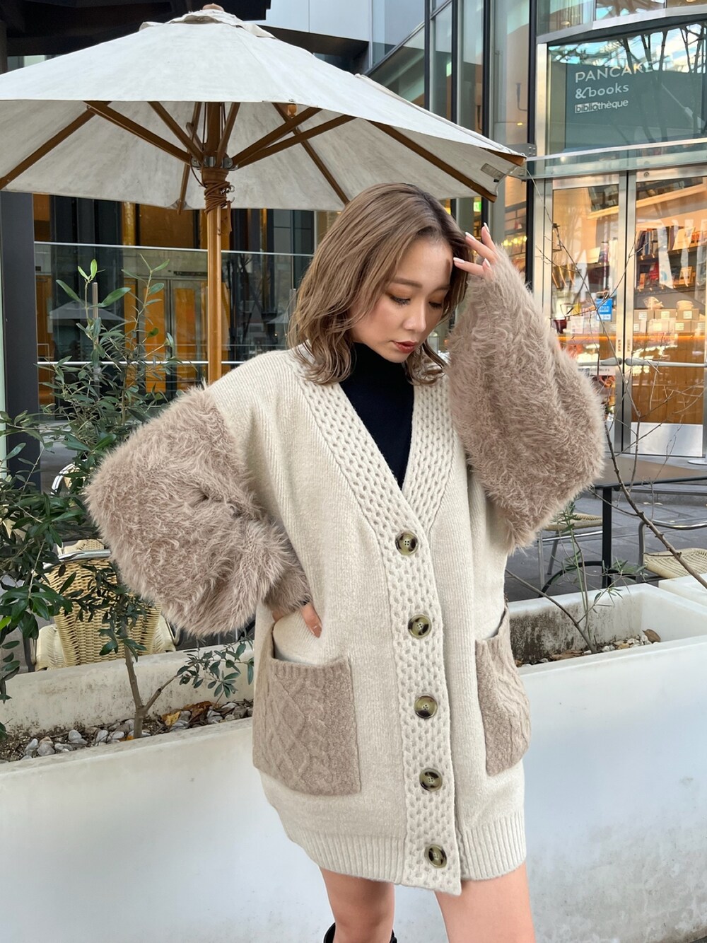 ベージュ系のカーディガン/ボレロ、ブラック系のニット/セーター、ブラック系のブーツを着用したレディースの秋コーディネートの5枚目の写真