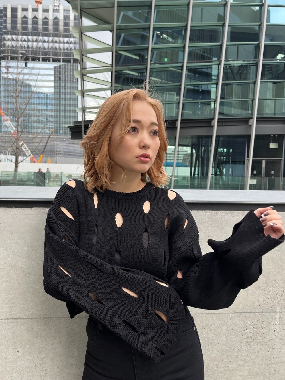 ホワイト系のブルゾン、ブラック系のニット/セーター、ブラック系のデニムパンツを着用したレディースの冬コーディネートの8枚目の写真