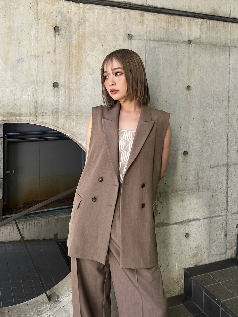 ブラウン系のベスト、ホワイト系のタンクトップ、ブラウン系のその他パンツを着用したレディースの夏コーディネートの3枚目の写真