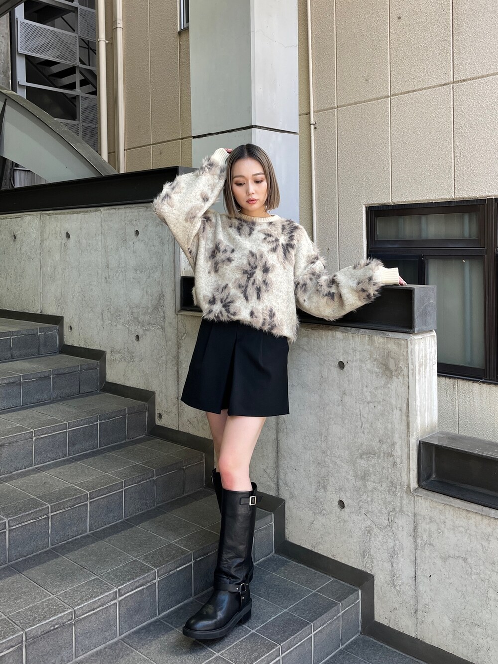 ホワイト系のニット/セーター、ブラック系のブーツを着用したレディースの秋コーディネートの7枚目の写真