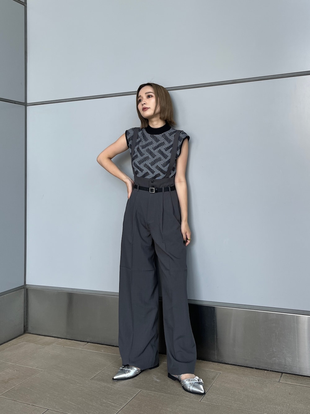 ブラック系のニット/セーター、グレー系のその他パンツ、シルバー系のパンプスを着用したレディースの夏コーディネートの2枚目の写真