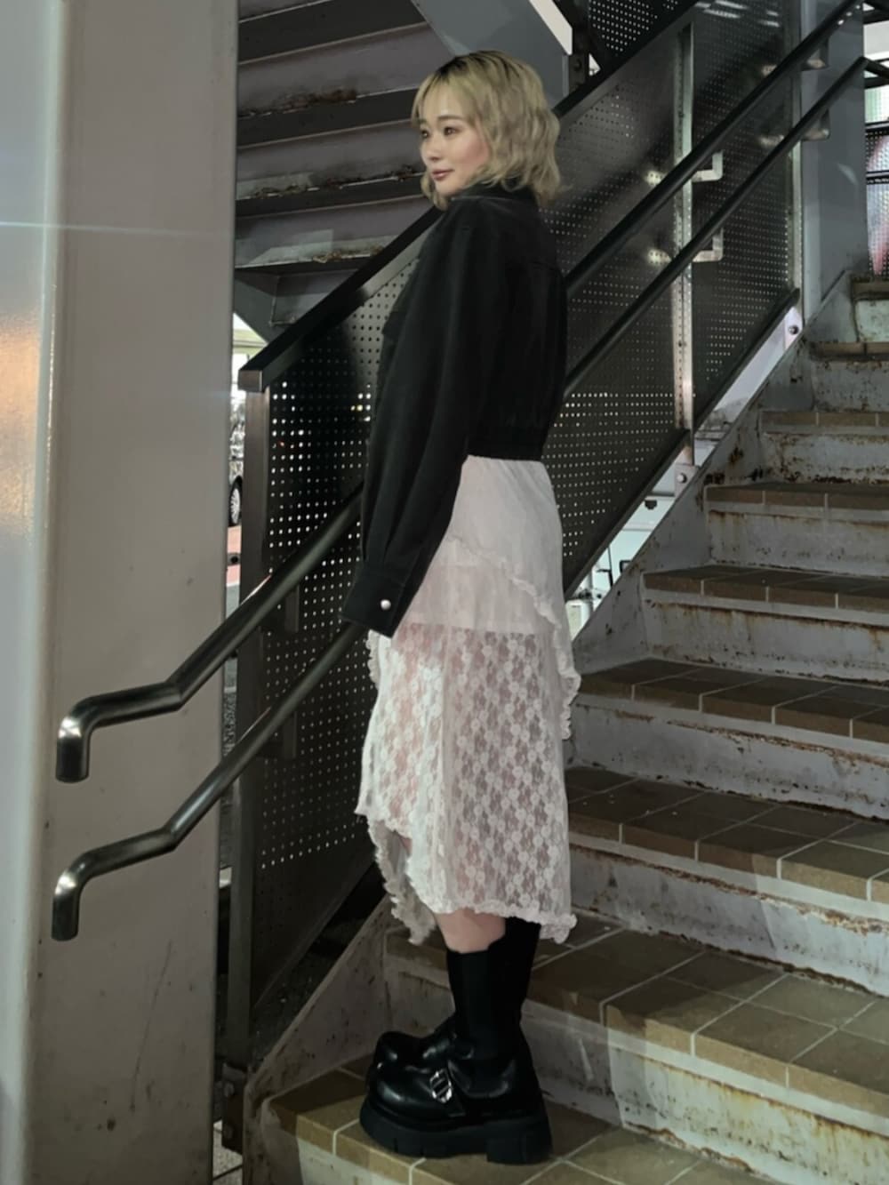 ブラック系のブーツ、ブラック系のブルゾンを着用したレディースの春コーディネートの2枚目の写真