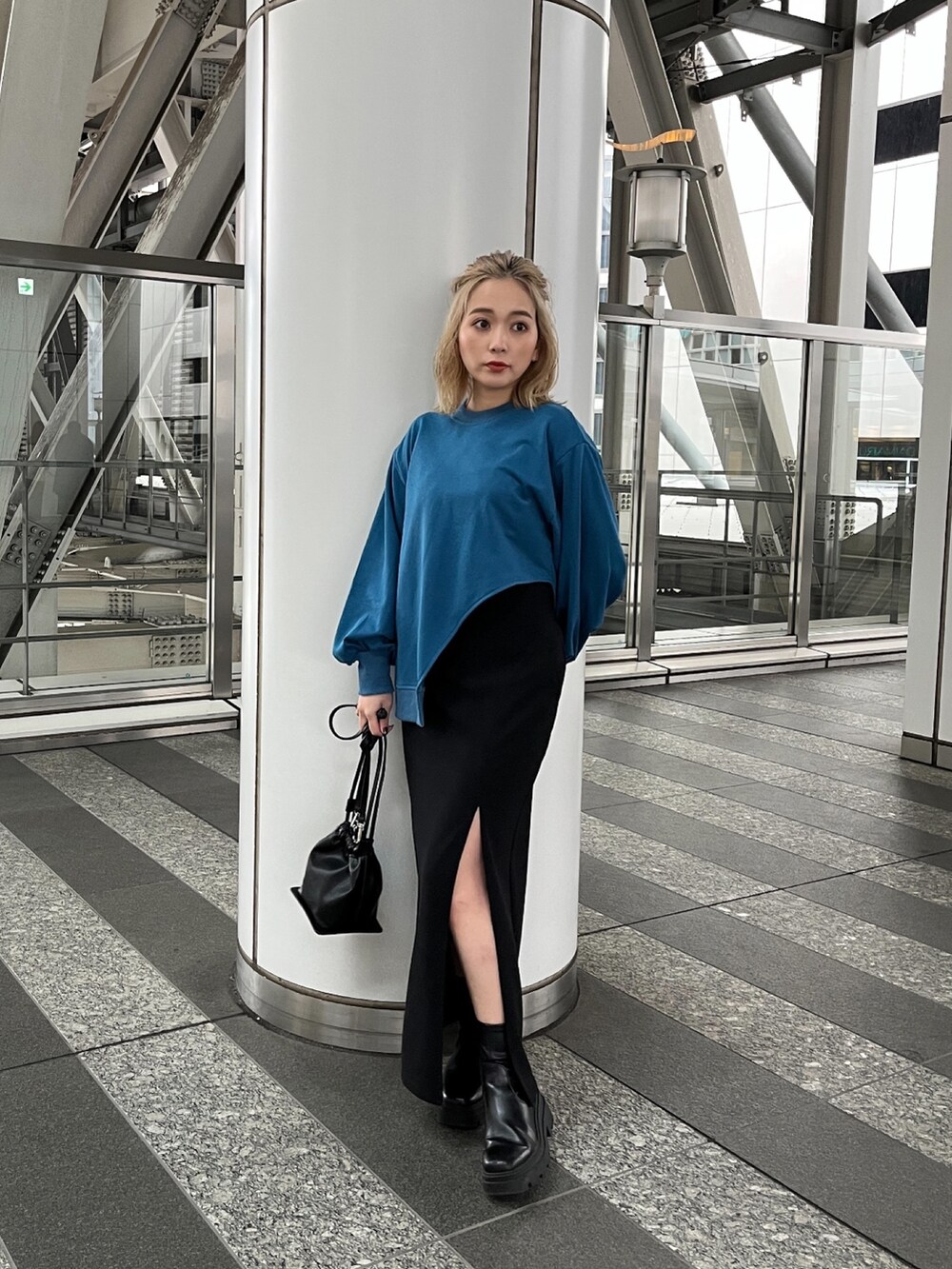 ブルー系のTシャツ/カットソー、ブラック系のスカート、ブラック系のハンドバッグを着用したレディースの冬コーディネートの3枚目の写真