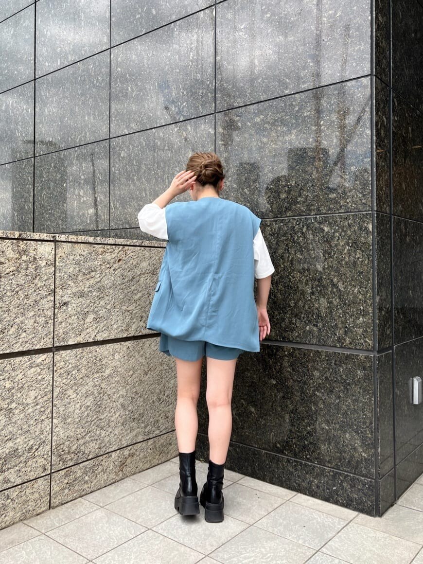 ホワイト系のTシャツ/カットソー、ブルー系のベスト、ブルー系のスラックスを着用したレディースの夏コーディネートの4枚目の写真