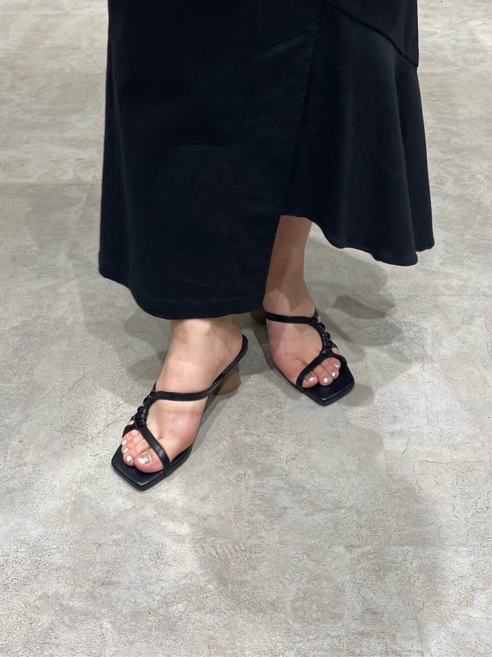 ブラック系のスカート、ホワイト系のシャツ/ブラウス、ブラック系のサンダルを着用したレディースの春コーディネートの8枚目の写真