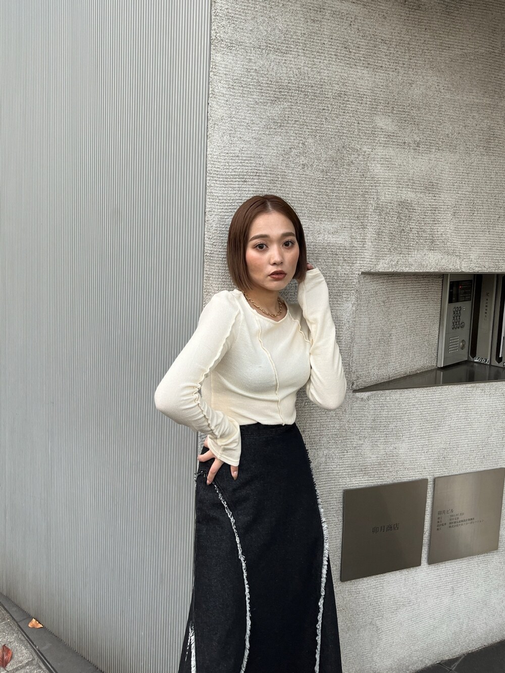 ホワイト系のTシャツ/カットソー、ブラック系のデニムスカートを着用したレディースの秋コーディネートの4枚目の写真