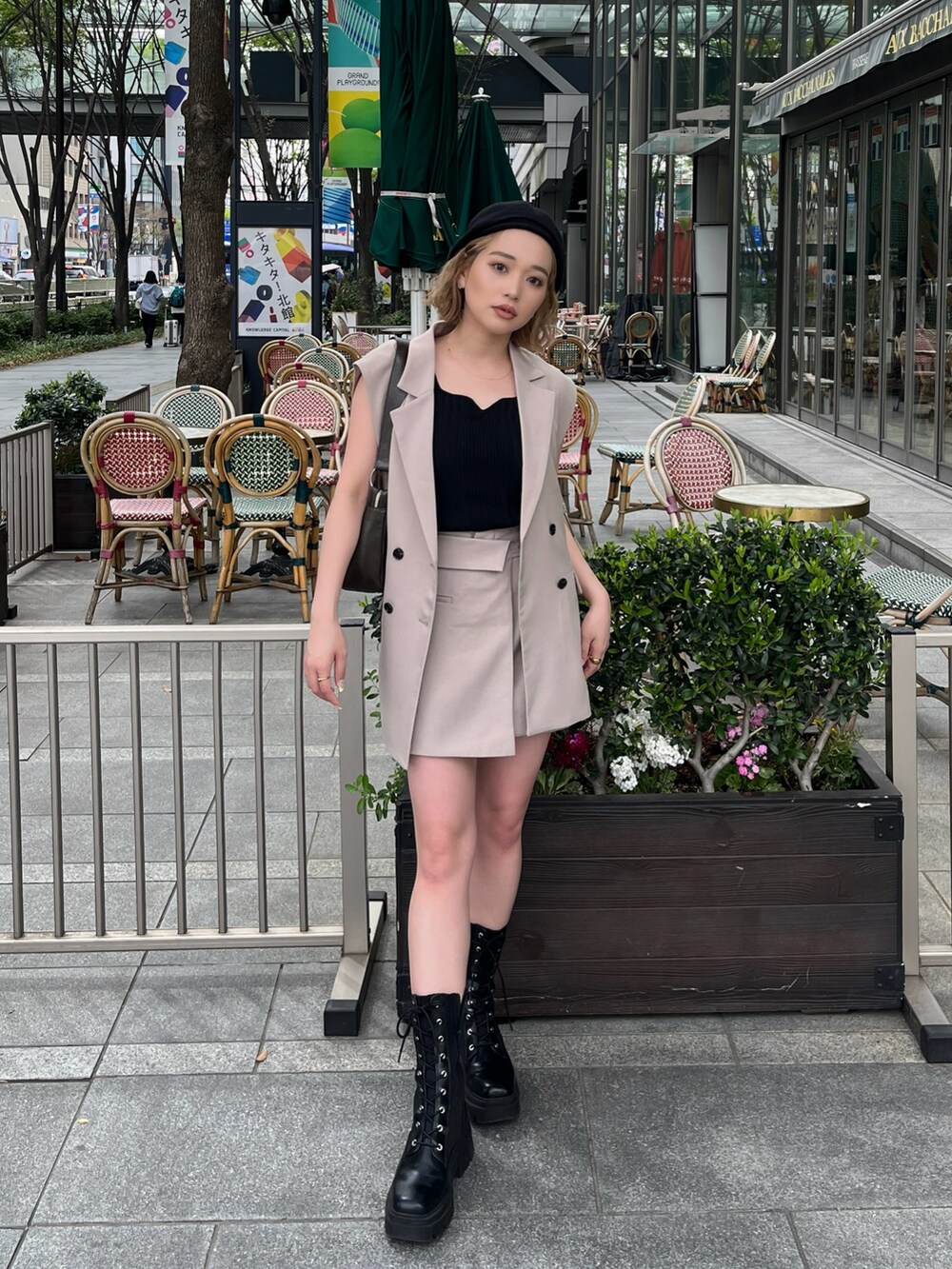 ブラック系のタンクトップ、ベージュ系のベスト、ブラウン系のハンドバッグを着用したレディースの春コーディネートの3枚目の写真