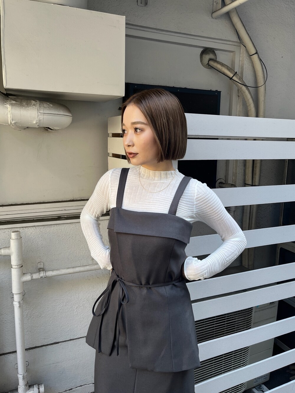 グレー系のシャツ/ブラウス、グレー系のスカート、ホワイト系のニット/セーターを着用したレディースの冬コーディネートの5枚目の写真