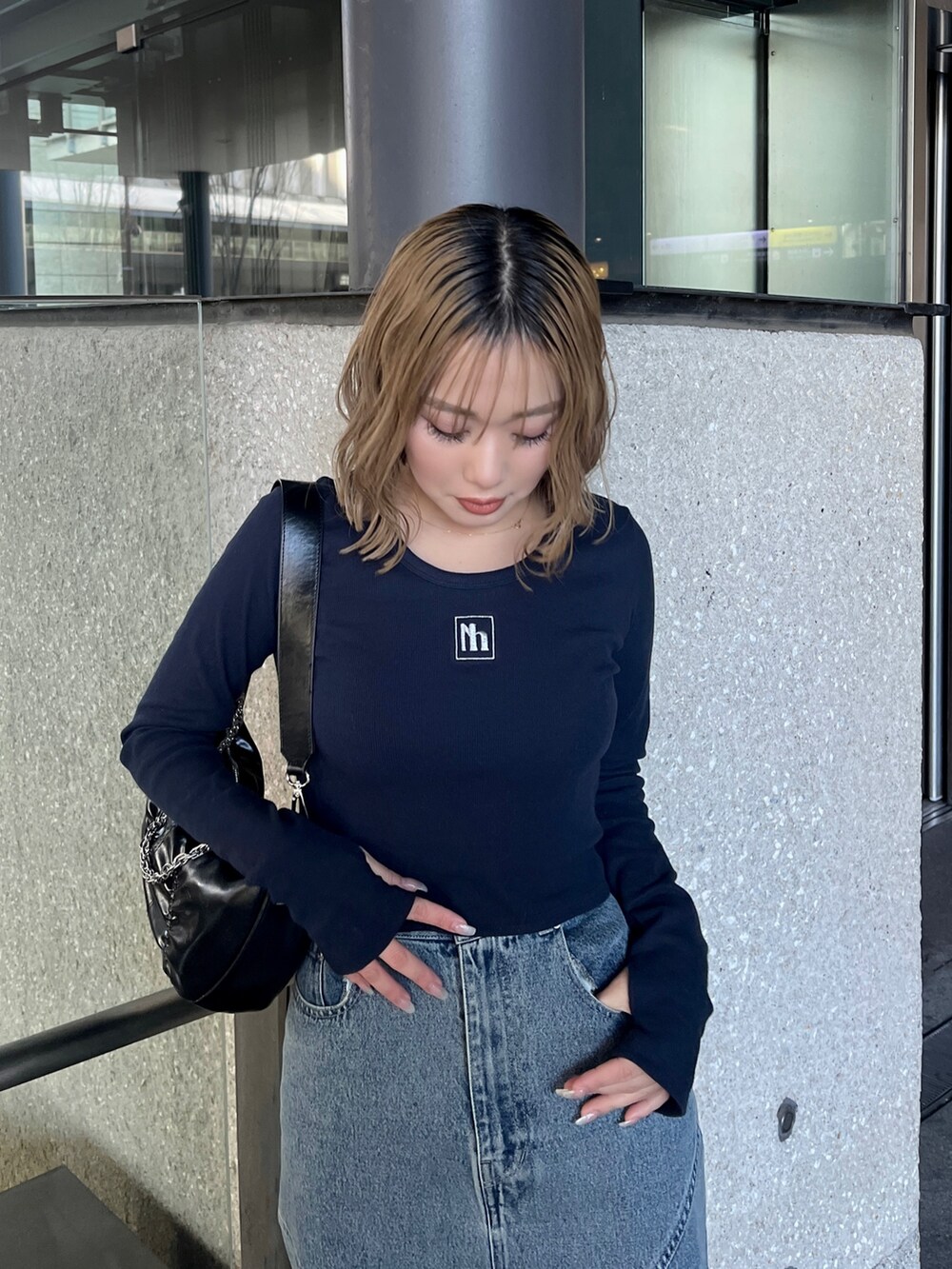 ブルー系のTシャツ/カットソー、ブルー系のデニムスカート、ブラック系のショルダーバッグを着用したレディースの春コーディネートの4枚目の写真