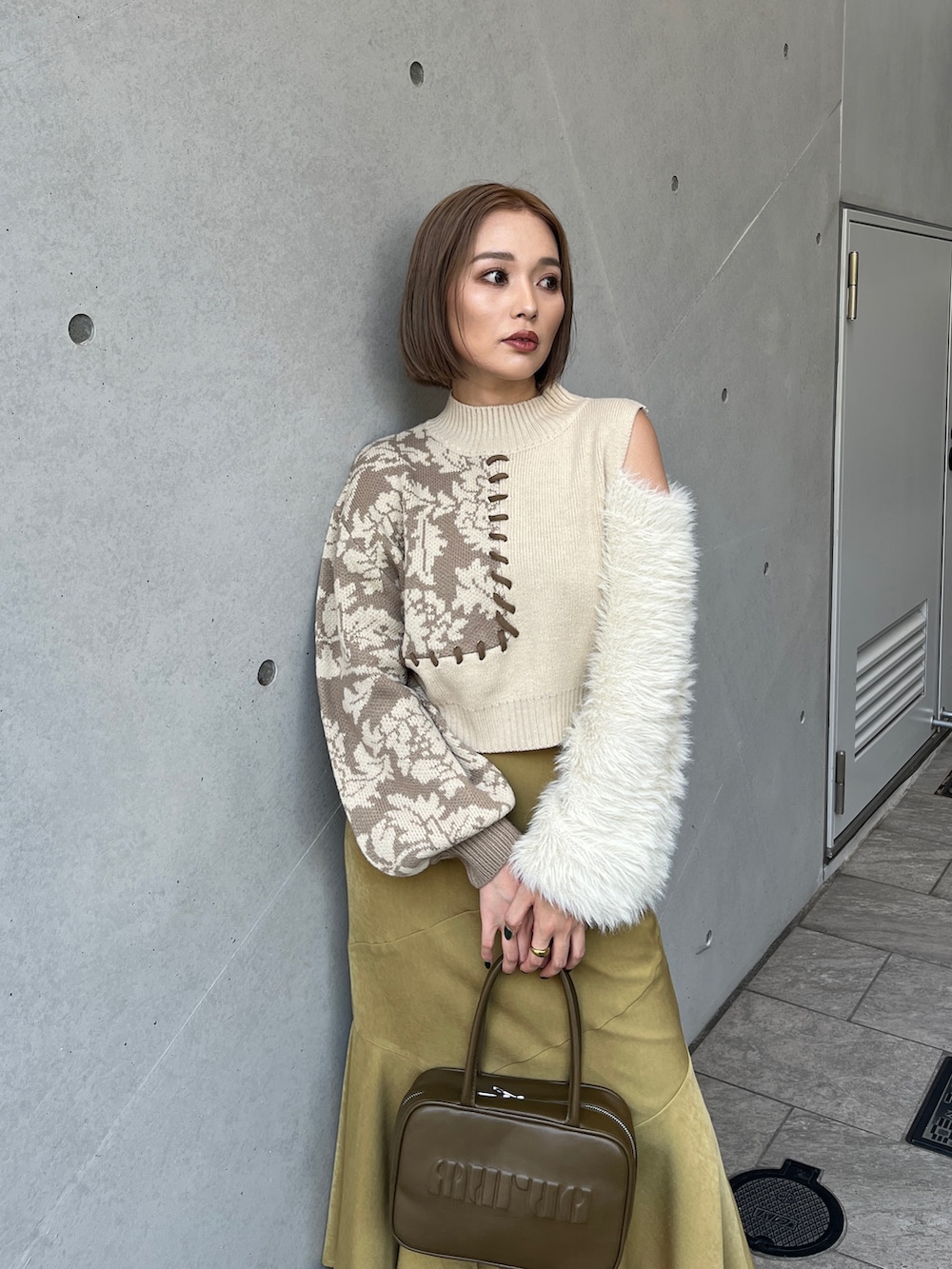 ホワイト系のニット/セーター、イエロー系のボストンバッグ、ホワイト系のブーツを着用したレディースの秋コーディネートの5枚目の写真