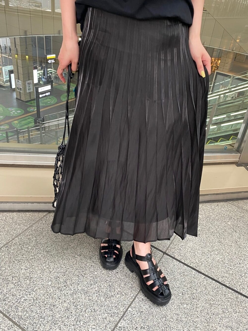 ブラック系のスカート、ブラック系のハンドバッグ、ブラック系のTシャツ/カットソーを着用したレディースの春コーディネートの6枚目の写真