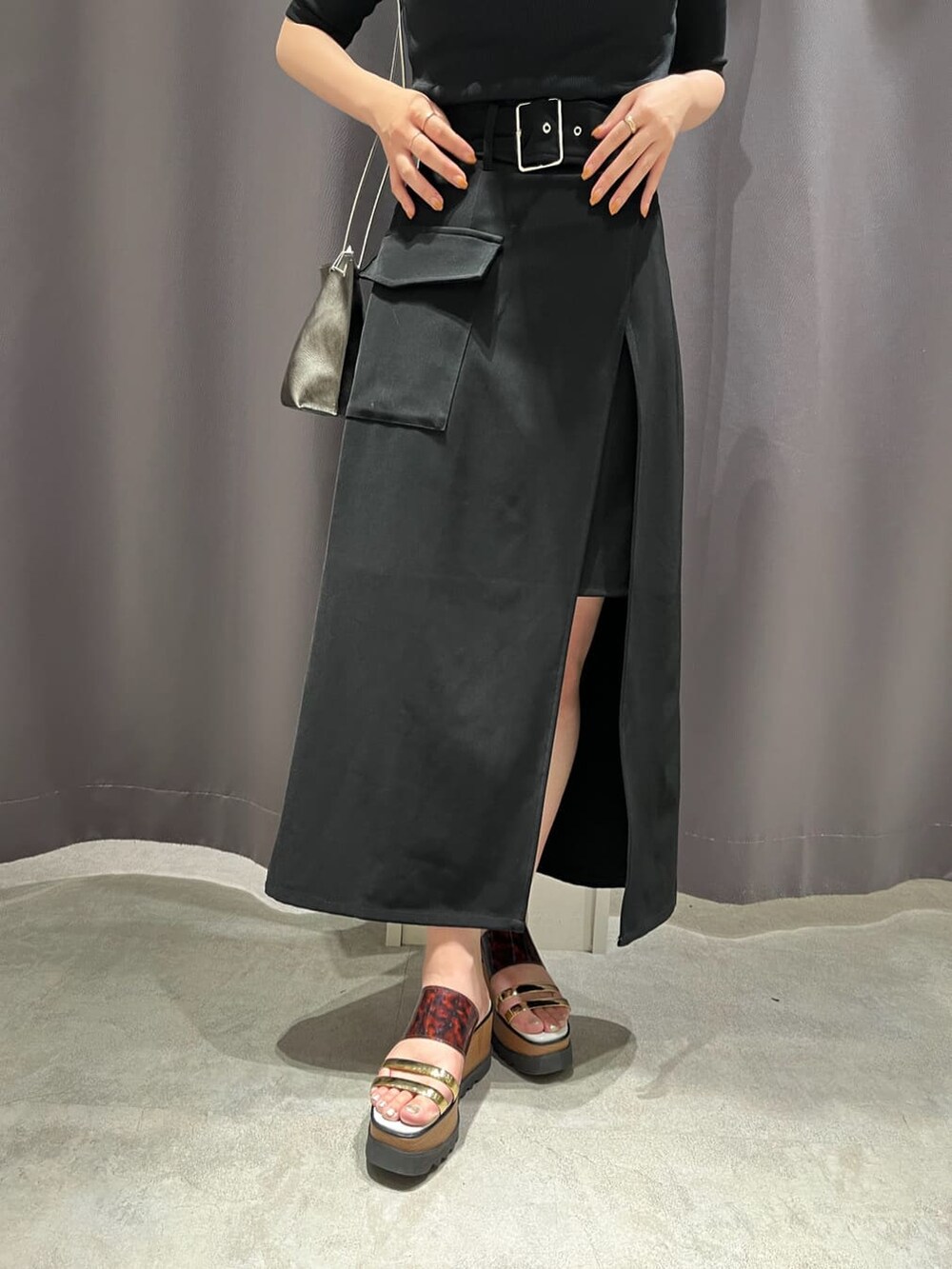 ブラック系のスカート、その他のサンダル、ブラック系のショルダーバッグを着用したレディースの夏コーディネートの6枚目の写真