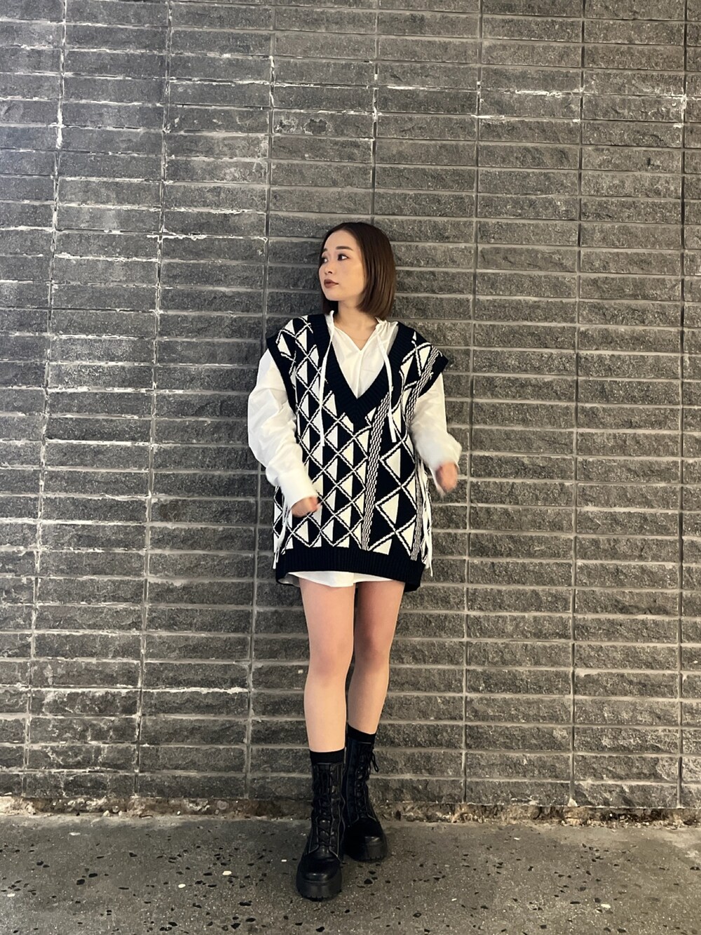 ホワイト系のシャツ/ブラウス、その他のベスト、ブラック系のブーツを着用したレディースの冬コーディネートの3枚目の写真