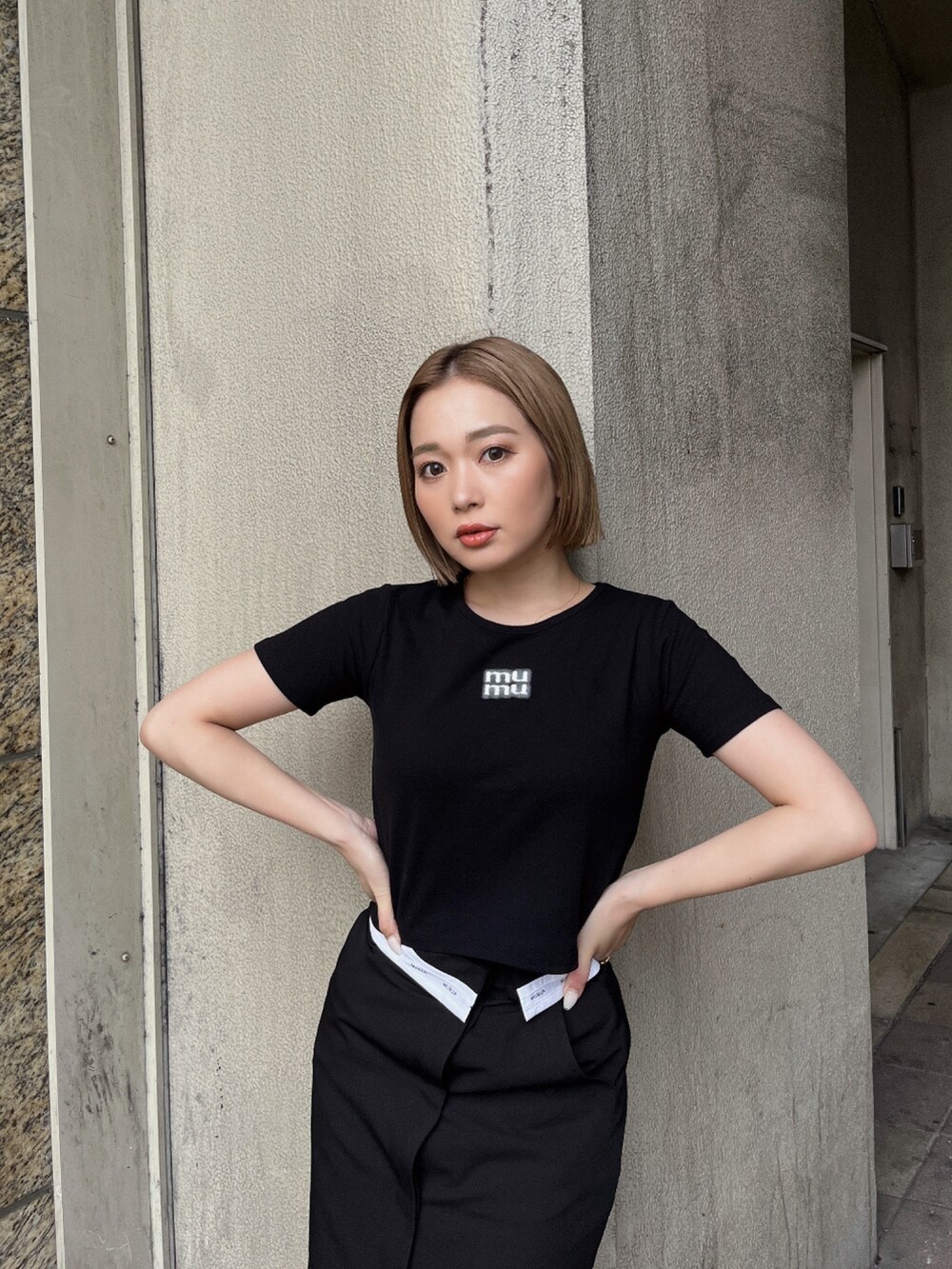 ブラック系のTシャツ/カットソー、ブラック系のスカート、ブラック系のサンダルを着用したレディースの夏コーディネートの4枚目の写真