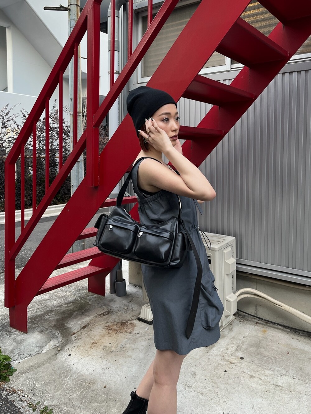 グレー系のワンピース、ブラック系のブーツ、ブラック系のタンクトップを着用したレディースの春コーディネートの4枚目の写真
