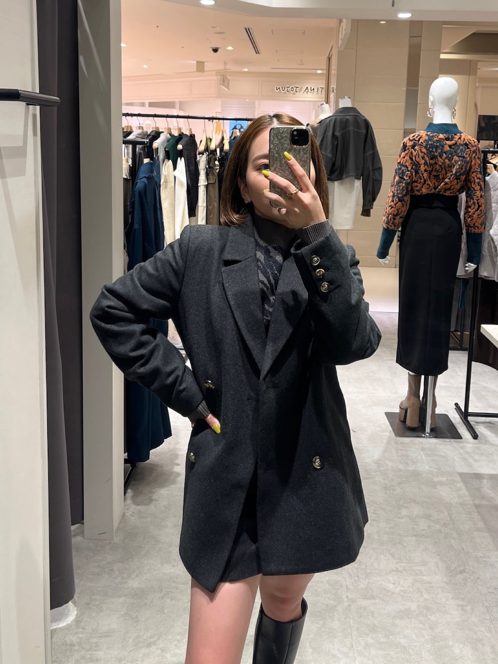 グレー系のテーラードジャケット、グレー系のスカート、グレー系のニット/セーターを着用したレディースの秋コーディネートの3枚目の写真